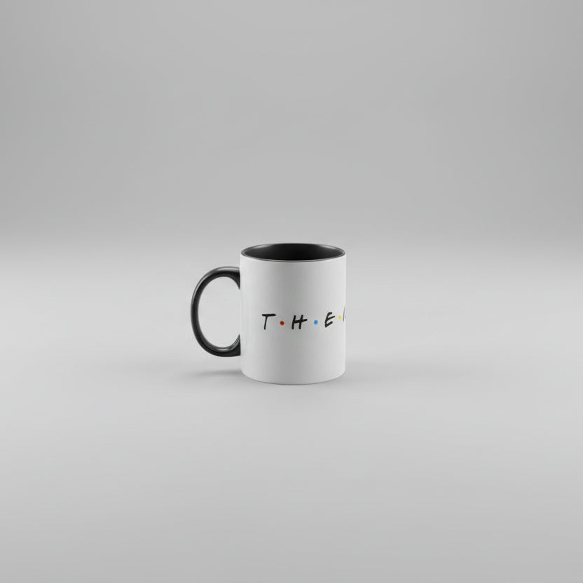 A white ceramic mug with the text 'T.H.E.A.T.R.E' printed in black on the front, featuring a black handle.